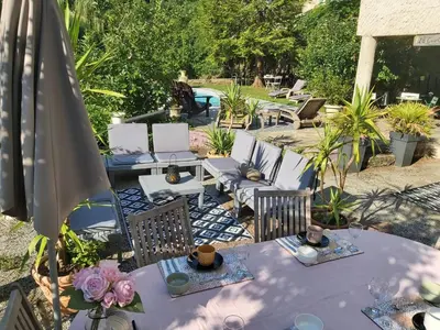 a patio with tables and chairs and an umbrella at Burlats in Burlats