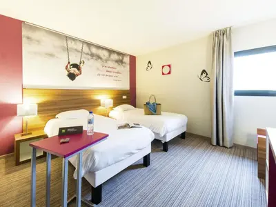 a hotel room with two beds and a table at ibis Styles Castres in Castres