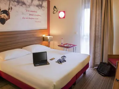 a hotel room with a bed with a laptop on it at ibis Styles Castres in Castres