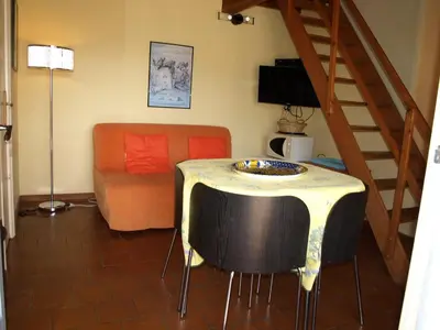 a living room with a table and a couch at La Bergerie et La Grange du Moulin de Trédos in Vélieux
