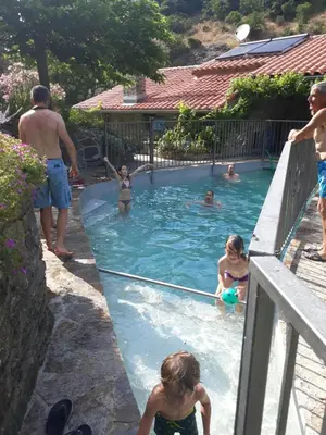 a group of people in a swimming pool at La Bergerie et La Grange du Moulin de Trédos in Vélieux