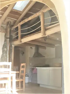 a loft bed in a room with a table and chairs at La Bergerie et La Grange du Moulin de Trédos in Vélieux