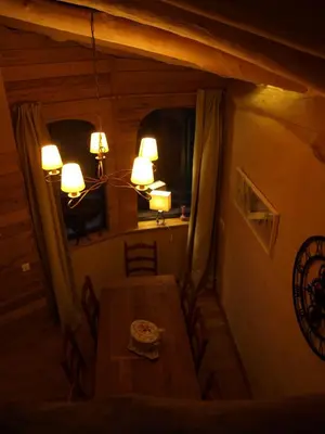 a dining room with a table and a chandelier at La Bergerie et La Grange du Moulin de Trédos in Vélieux