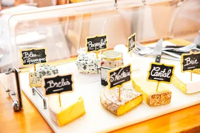 a display case filled with different types of cheeses at Logis Hôtel et Restaurant La Bombardière in Cuq-Toulza