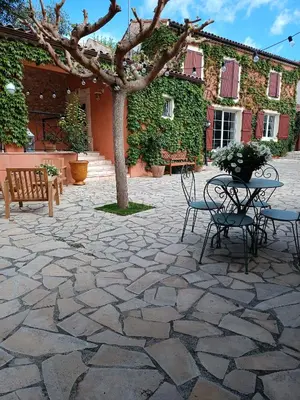 a patio with a table and chairs and a tree at Aux Berges du Canal in Capestang