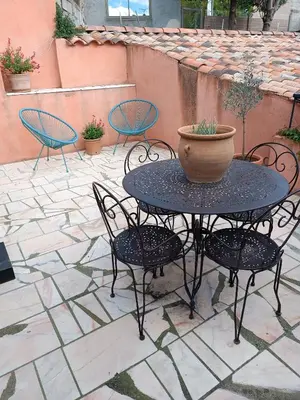 a table and chairs with a pot on a patio at Aux Berges du Canal in Capestang