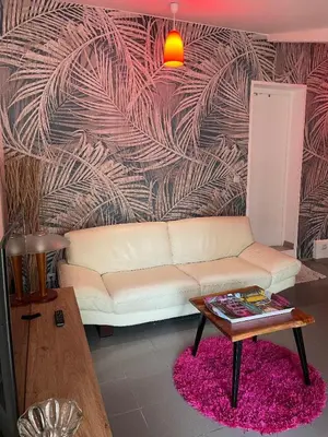 a living room with a white couch and a table at gîtes Studio de tourisme du Domaine Piscine Spa Balnéo in Lescout