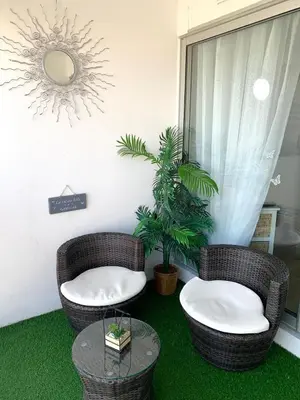 two wicker chairs and a table in a room at Cap Gruissan Vacances (11) in Gruissan