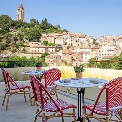 a group of tables and chairs with a view of a city at Ecole Olargues - Chambres & restaurant - Teritoria in Olargues