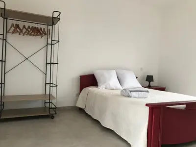 a bedroom with a bed and a shelf at VILLA PINTOURINA in Sallèles-dʼAude