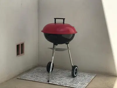 a bbq grill with a red lid on a stand at VILLA PINTOURINA in Sallèles-dʼAude