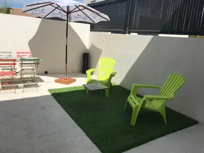 two green chairs and a table with an umbrella at VILLA PINTOURINA in Sallèles-dʼAude
