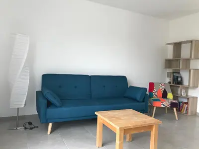 a blue couch in a living room with a table at VILLA PINTOURINA in Sallèles-dʼAude