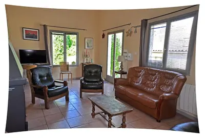 a living room with a leather couch and chairs at Le Moulin du Christ in Peyrefitte-sur-lʼHers