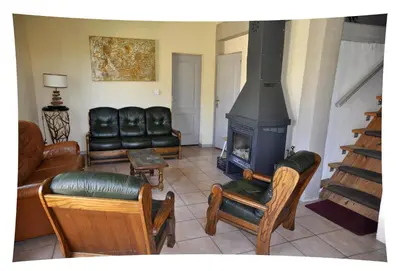 a living room with leather furniture and a fireplace at Le Moulin du Christ in Peyrefitte-sur-lʼHers