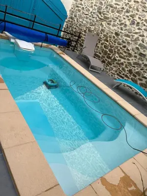 a swimming pool with a hose on top of it at Chez Elia, pour les amoureux des vieilles pierres in Cesseras