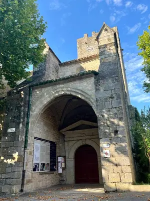 an entrance to a stone building with a red door at Chez Elia, pour les amoureux des vieilles pierres in Cesseras