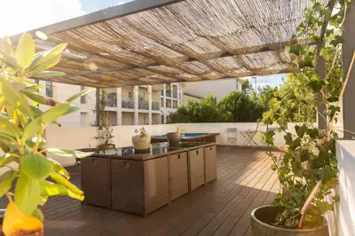 an outdoor patio with a wooden deck with a pergola at Hotel Galla Placidia in Narbonne