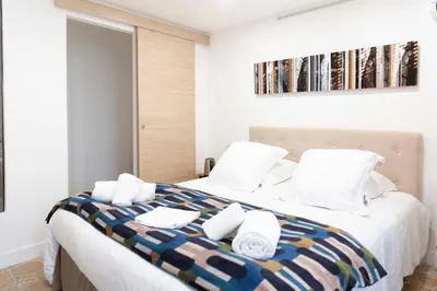 a bedroom with a large bed with towels on it at Hotel Galla Placidia in Narbonne