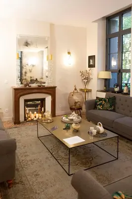 a living room with a fireplace and a coffee table at Hotel Galla Placidia in Narbonne