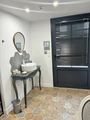 a bathroom with a sink and a mirror on a table at Hotel Galla Placidia in Narbonne