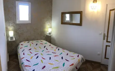 a bedroom with a bed and a mirror on the wall at Les Palmiers de Gruissan, T2, Vue Port ! in Gruissan