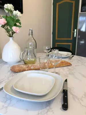a white plate on a table with wine glasses at Les Palmiers de Gruissan, T2, Vue Port ! in Gruissan