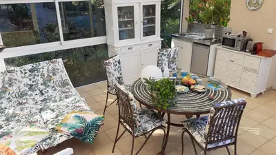 a kitchen with a table and chairs in a kitchen at La Bergerie in Lagarrigue