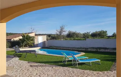 a swimming pool with two chairs and a table at 3 Bedroom Nice Home In Quarante in Quarante
