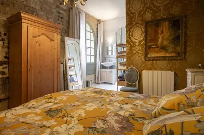 a large living room with a table and chairs at La Bastide des Roses in La Bastide-sur-lʼHers