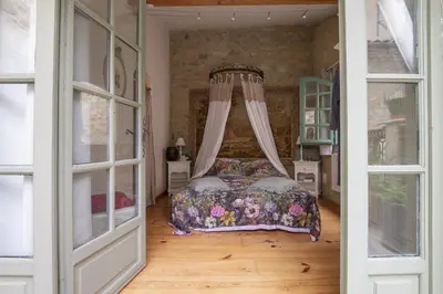 a bedroom with a bed with a floral bedspread at La Bastide des Roses in La Bastide-sur-lʼHers