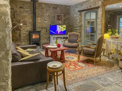 a living room with a couch and a tv at La Bastide des Roses in La Bastide-sur-lʼHers