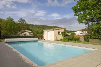 a swimming pool in the backyard of a house at La Bastide des Roses in La Bastide-sur-lʼHers