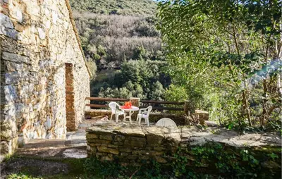 a table and chairs sitting next to a stone wall at 2 Bedroom Amazing Home In Olargues in Olargues