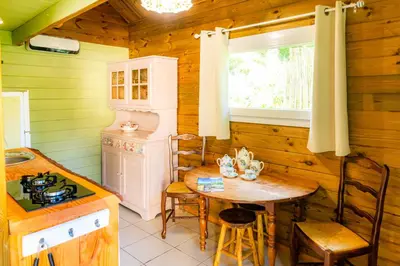 a kitchen with a table and a stove and a window at Les Cabanes d'Hestia in La Salvetat