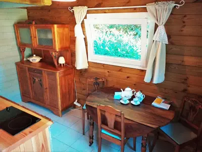 a dining room with a table and a window at Les Cabanes d'Hestia in La Salvetat
