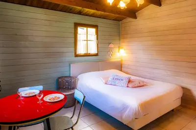 a small bedroom with a bed and a table at Les Cabanes d'Hestia in La Salvetat