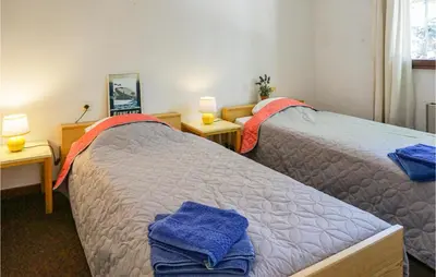 two beds in a room with two lamps and towels at Awesome Home In Pierrerue in Pierrerue