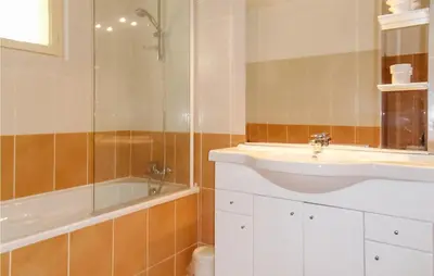 a bathroom with a sink and a shower and a tub at Awesome Home In Pierrerue in Pierrerue