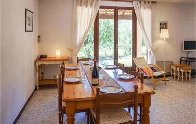 a dining room table with a bottle of wine on it at Awesome Home In Pierrerue in Pierrerue