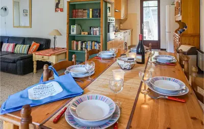 a wooden table with plates and a bottle of wine at Awesome Home In Pierrerue in Pierrerue
