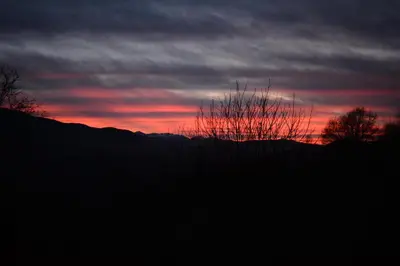 a sunset with a tree in the foreground at Petit Gîte TARA avec SPA - Ariege Pyrénées in Péreille