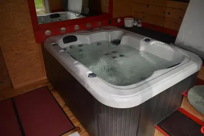a bath tub filled with water in a bathroom at Petit Gîte TARA avec SPA - Ariege Pyrénées in Péreille