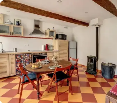 a kitchen with a table and chairs in a room at La maison aux volets bleus in Caunes-Minervois