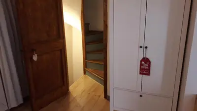 a room with a door and a stairway with a sign at La maison aux volets bleus in Caunes-Minervois