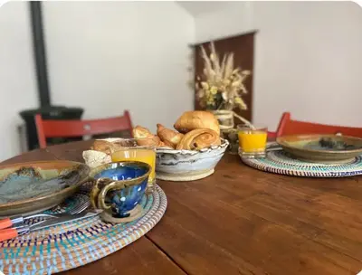 a wooden table with plates of food and drinks on it at La maison aux volets bleus in Caunes-Minervois