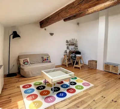 a living room with a couch and a table on a rug at La maison aux volets bleus in Caunes-Minervois