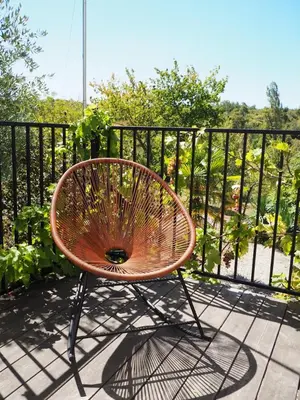 a wooden table with chairs and an umbrella on a deck at Domaine du Cammazet in Lapenne