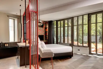 a bedroom with a bed and a desk and windows at Domaine de la JASSO, Demeure de grand luxe au pied de la Cité de Carcassonne, piscines et parc animalier in Carcassonne