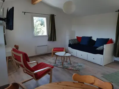 a living room with a couch and a chair at Studio dans un cadre champêtre in Mas-Saintes-Puelles